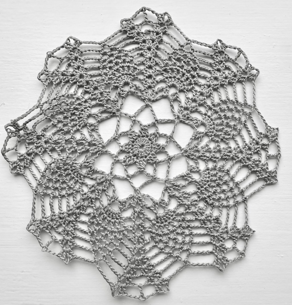 Round hand crocheted doily with a traditional pineapple design.